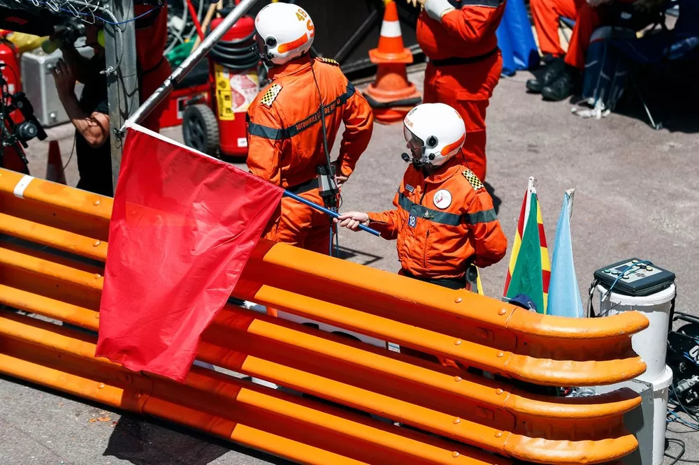 Oficiales de pista ondean una bandera roja