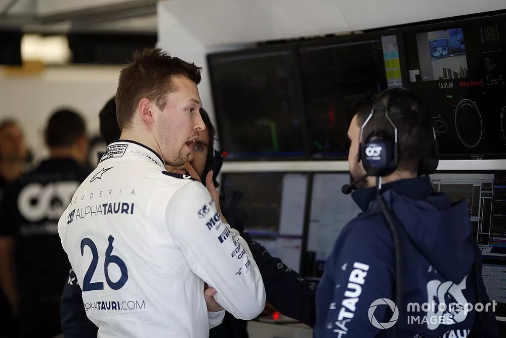 Daniil Kvyat, AlphaTauri talks with a member of his team in the garage