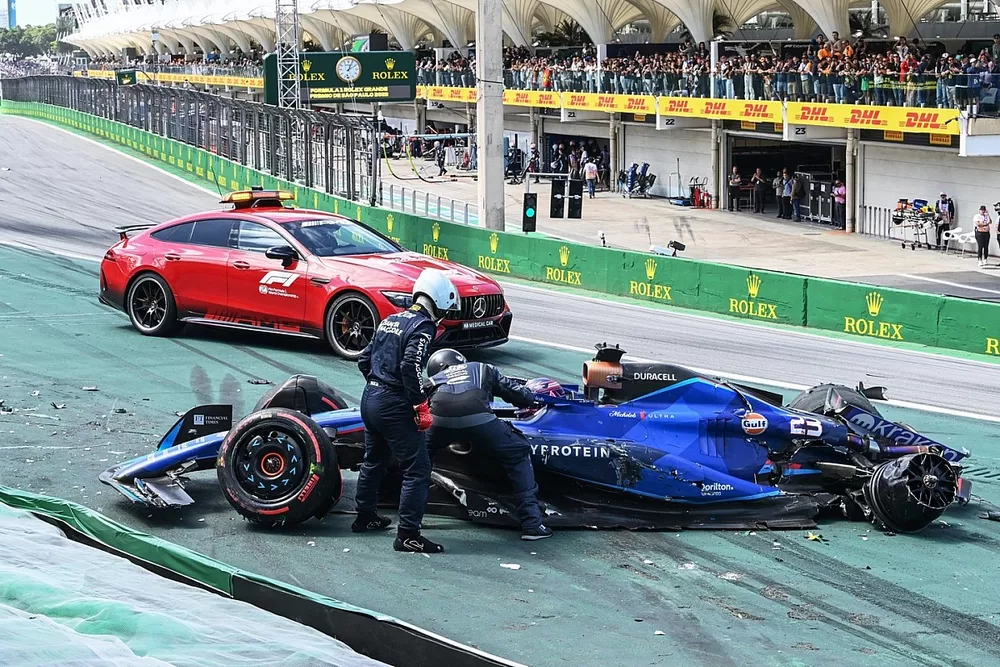 Delegados m&eacute;dicos de la FIA asisten a Alex Albon, Williams FW45, tras un choque en la salida con Kevin Magnussen, Haas VF-23