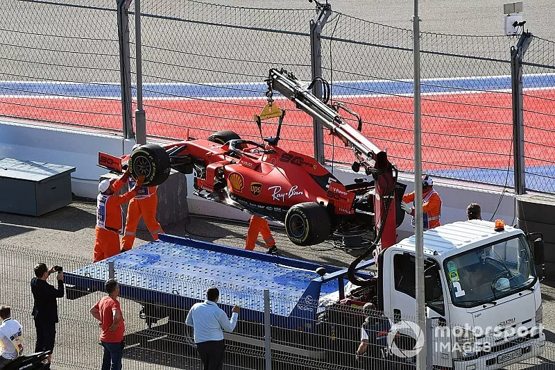 Los oficiales cargan el coche de Sebastian Vettel, Ferrari SF90, en una gr&uacute;a