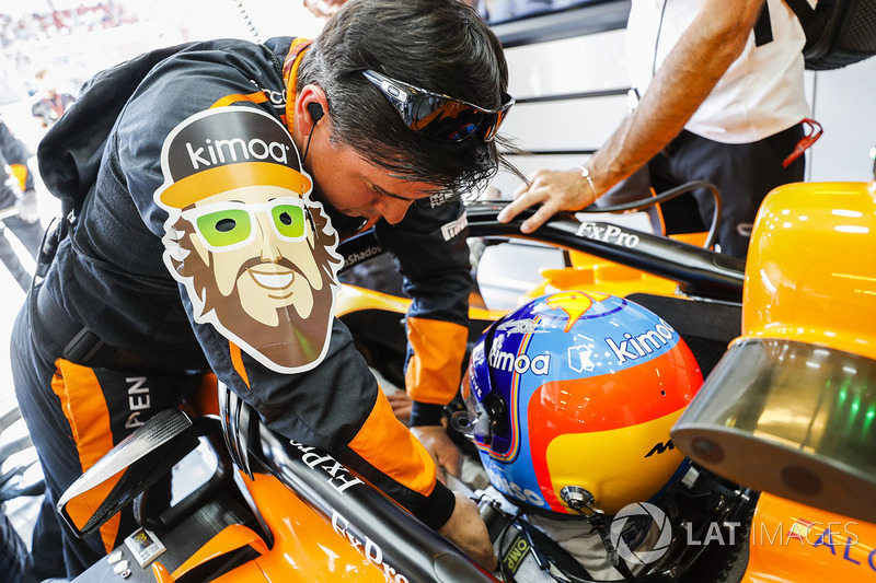 An engineer helps Fernando Alonso, McLaren MCL33, strap in to his car