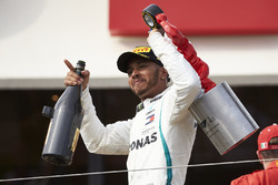 Le vainqueur Lewis Hamilton, Mercedes AMG F1, quitte le podium avec son trophée et le champagne