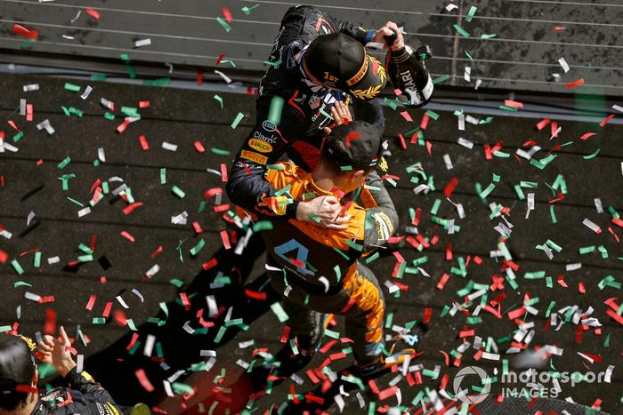 Lando Norris, McLaren, 2ª posición, Max Verstappen, Red Bull Racing, 1ª posición, se felicitan mutuamente en el podio.