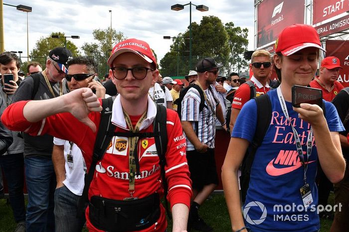 Spectators show their reaction to the news of the cancellation of the Grand Prix