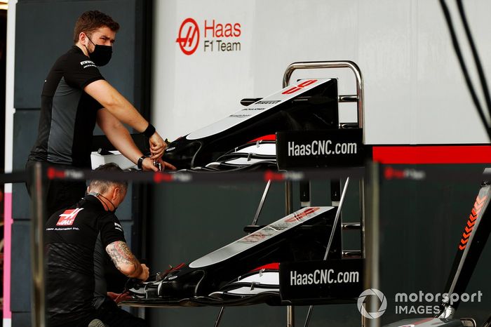 Los conos de la nariz y las alas delanteras del monoplaza de Romain Grosjean Haas VF-20 son trabajados por un miembro del equipo