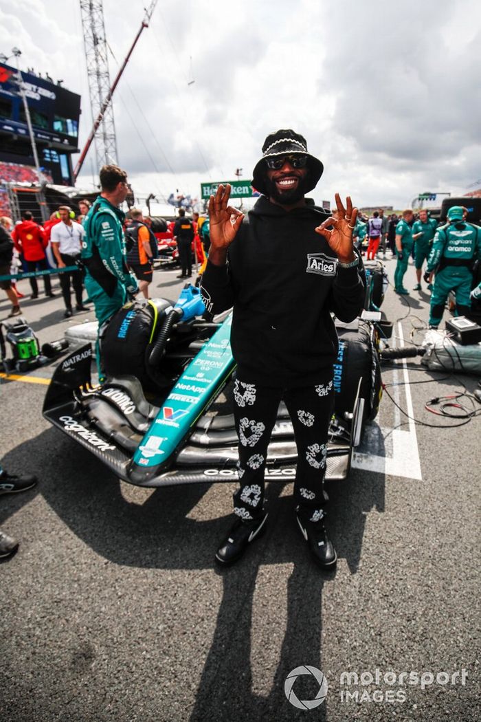 El rapero Tinie Tempah en la parrilla con el coche de Fernando Alonso, el Aston Martin AMR23