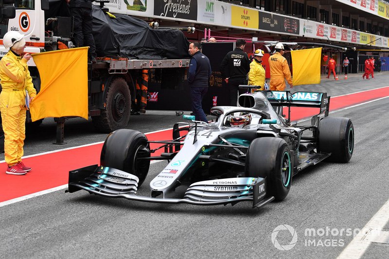 Lewis Hamilton, Mercedes-AMG F1 W10 passes the recovered car of Romain Grosjean, Haas F1 Team VF-19