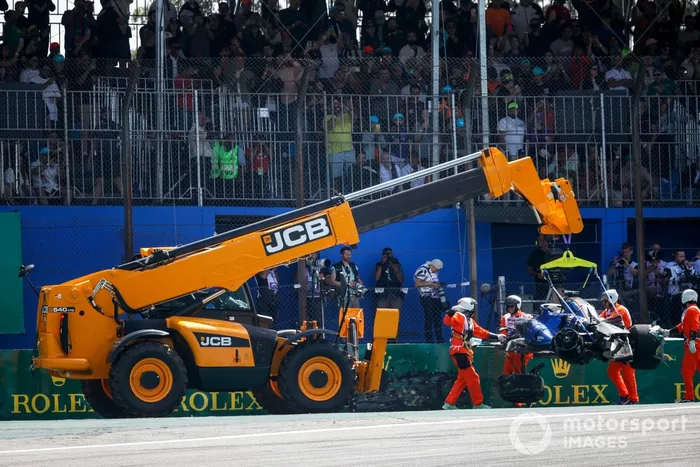 Los comisarios retiran del circuito el coche dañado de Alex Albon, Williams FW45