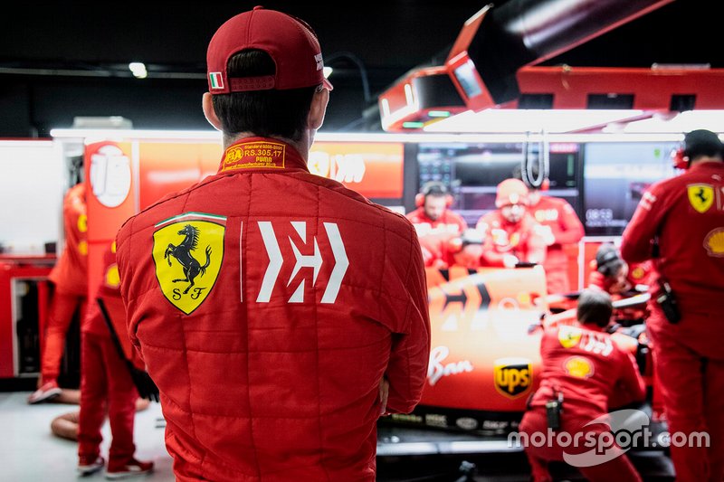 Charles Leclerc menyaksikan para mekanik Ferrari memperbaiki SF90
