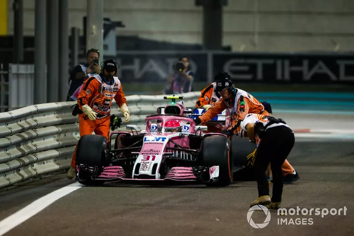 Oficiales mueven el auto de Esteban Ocon, Racing Point Force India VJM11, mientras se retira de la carrera por problemas técnicos