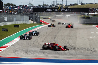 Kimi Raikkonen, Ferrari SF71H, leads Lewis Hamilton, Mercedes AMG F1 W09 EQ Power+, Valtteri Bottas, Mercedes AMG F1 W09 EQ Power+, Sebastian Vettel, Ferrari SF71H, Daniel Ricciardo, Red Bull Racing RB14, and the rest of the field on the opening lap