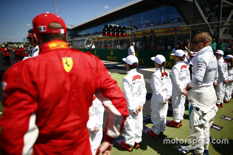 The drivers join the Grid Kid for the national anthem