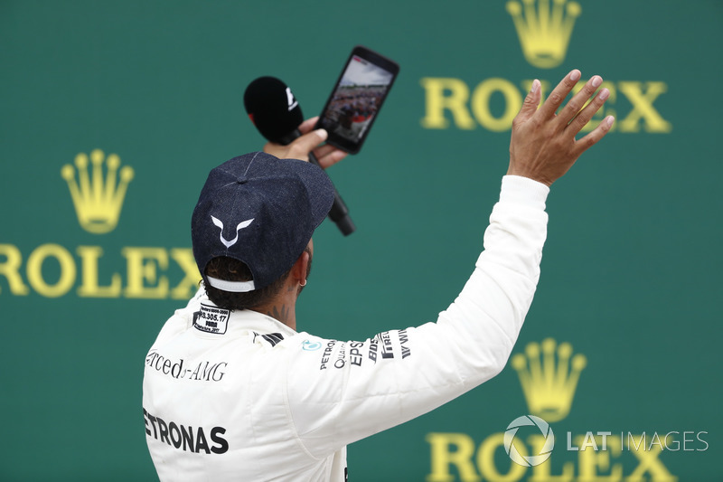 Podium: Race winner Lewis Hamilton, Mercedes AMG F1, takes a photo, the crowd in the background