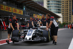 Des membres de Haas F1 Team poussent la voiture de Romain Grosjean Haas F1 Team VF-17 dans la pitlane