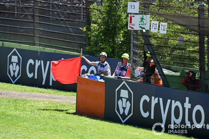 Un comisario agita la bandera roja