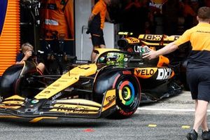 Un mecánico dirige a Lando Norris, McLaren MCL38, fuera del garaje