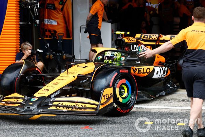 Un mecánico dirige a Lando Norris, McLaren MCL38, fuera del garaje