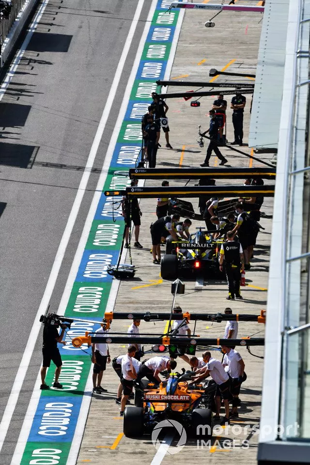 Daniel Ricciardo, Renault F1 Team R.S.20, y Carlos Sainz Jr., McLaren MCL35, in the pit lane