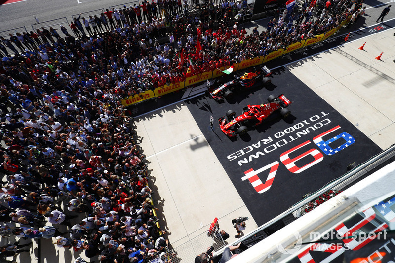 Kimi Raikkonen, Ferrari SF71H, talks to the media as his car sits in Parc Ferme with the car of Max Verstappen, Red Bull Racing RB14