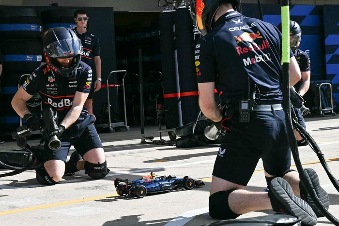 Red Bull Racing crew members perform a pit stop with a LEGO car