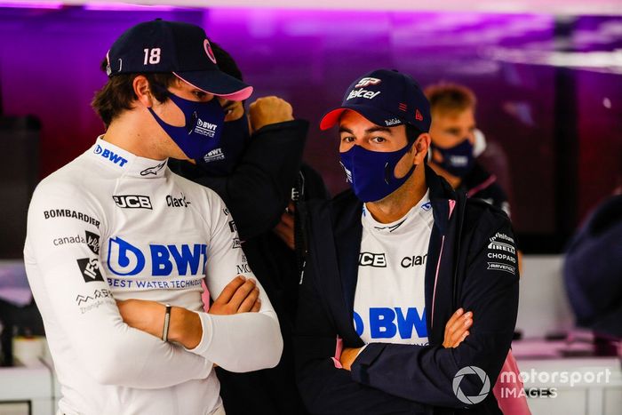 Lance Stroll, Racing Point, talks to Sergio Perez, Racing Point in the team's garage