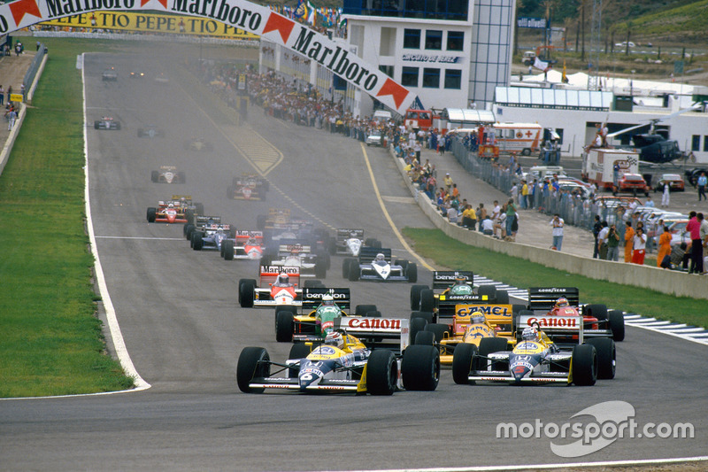 Nelson Piquet, Williams FW11B Honda and teammate Nigel Mansell, Williams FW11B Honda, lead Ayrton Senna, Lotus 99T Honda, at the start