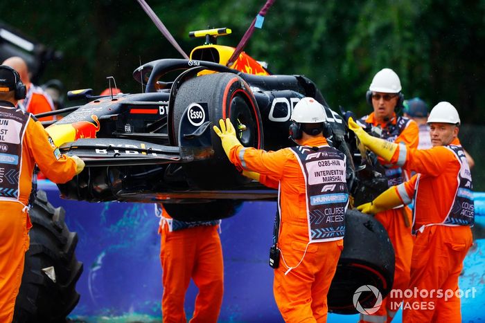 Los comisarios retiran el coche dañado de Sergio Pérez, Red Bull Racing RB20