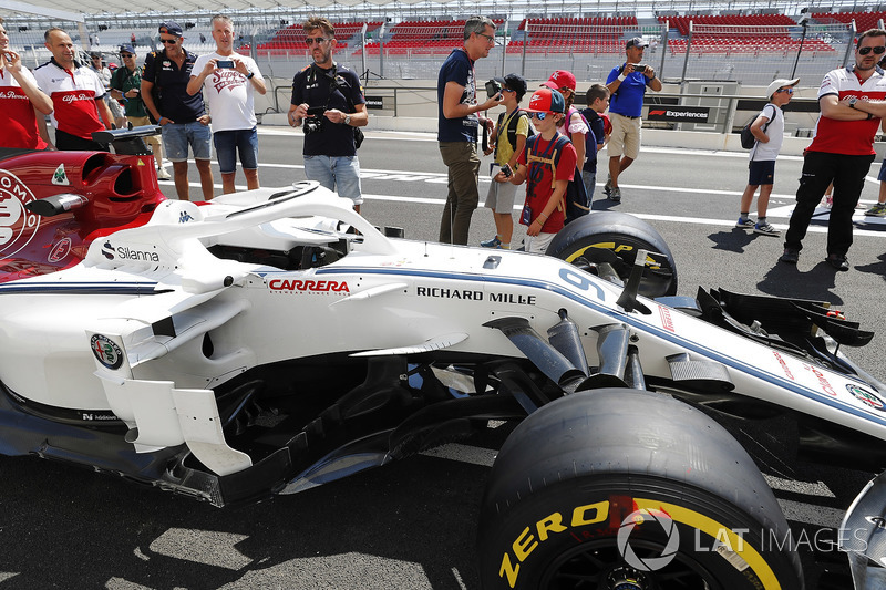 Dei tifosi fotografano la monoposto di Marcus Ericsson Sauber C37, sotto la supervisione dei membri del team Sauber
