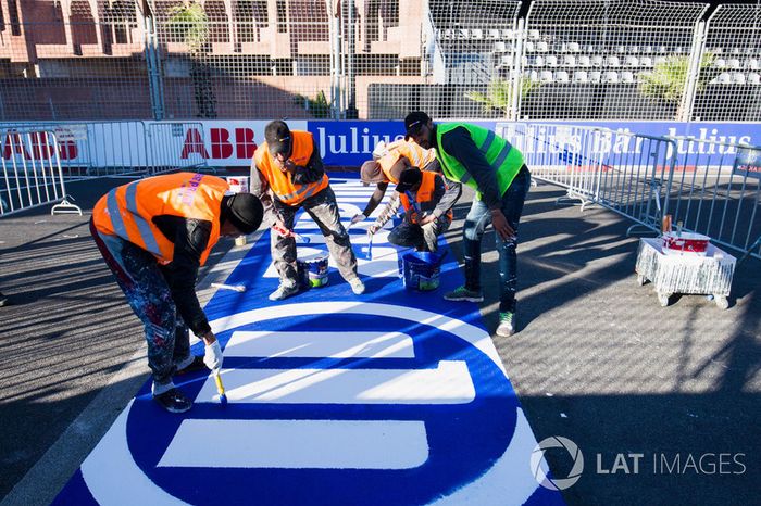  Trabajadores pintan el logo de Allianz en el circuito