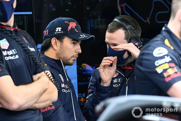 Sergio Pérez, Red Bull Racing, conversa con un ingeniero en el garaje