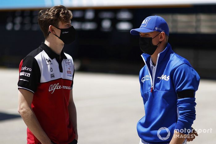 Callum Ilott, piloto de pruebas y reserva de Alfa Romeo Racing habla con Mick Schumacher, Haas F1 en el paddock