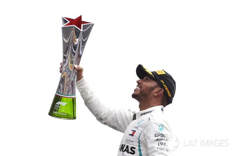 Lewis Hamilton, Mercedes AMG F1, celebrates on the podium by raising his winner's trophy