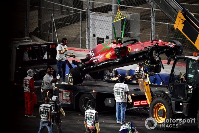 Los oficiales de pista retiran el coche dañado de Charles Leclerc, Ferrari SF21, del circuito