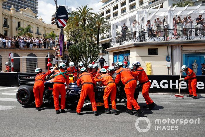 Los comisarios retiran del circuito el coche dañado de Sergio Pérez, Red Bull Racing RB20, tras un accidente en la primera vuelta.