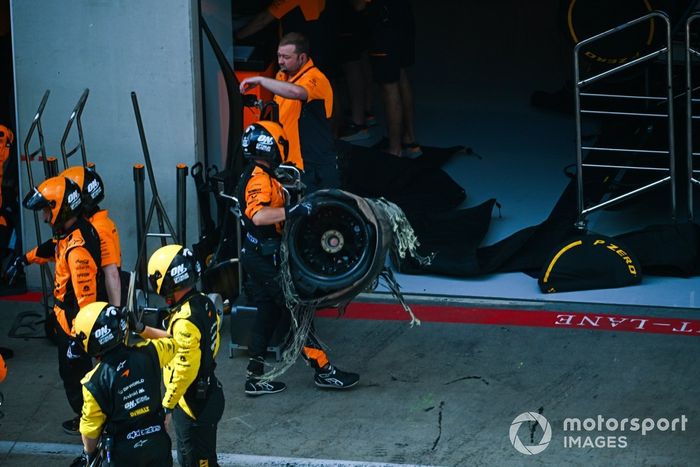 El neumático dañado es retirado del coche de Lando Norris, McLaren MCL38, tras el contacto con Max Verstappen, Red Bull Racing RB20.