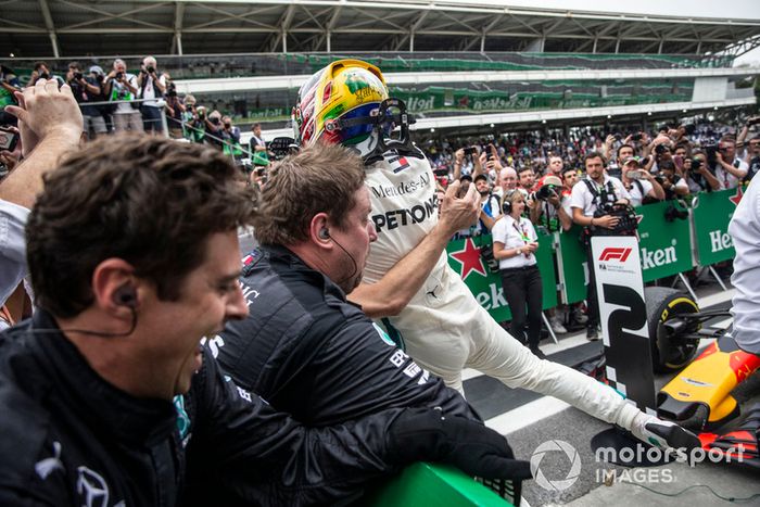 Las barreras se derrumban cuando Lewis Hamilton, Mercedes AMG F1 celebra con su mecánica en el Parc Ferme.