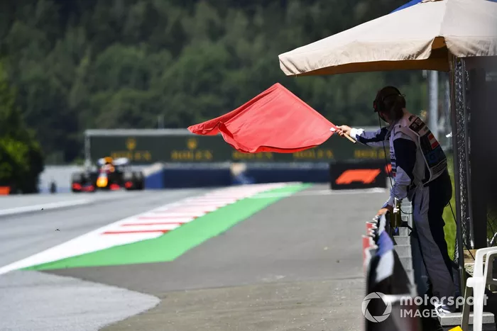 Marshall sventola una bandiera rossa mentre passa Max Verstappen, Red Bull Racing RB16