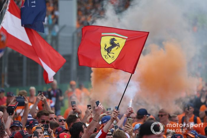 Los aficionados se lanzan al circuito con banderas de Ferrari y bengalas naranjas tras la carrera