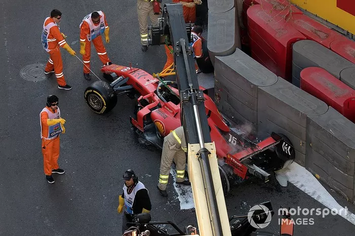 Los oficiales retiran el coche accidentado de Charles Leclerc, Ferrari SF90