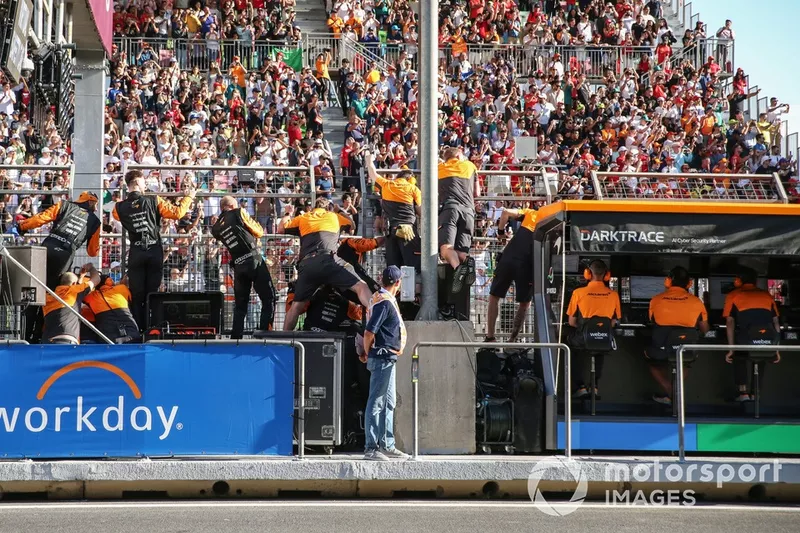 L'équipe McLaren monte sur le muret des stands pour encourager Oscar Piastri, McLaren MCL38, à franchir la ligne d'arrivée.