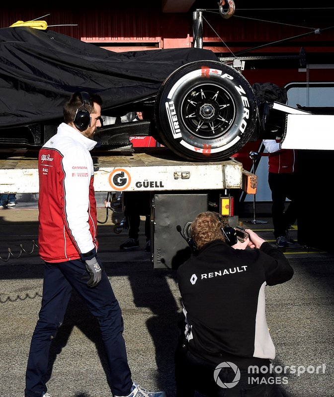 The Kimi Raikkonen Alfa Romeo Racing C38 is returned to the pits, and is photographed by a McLaren team member