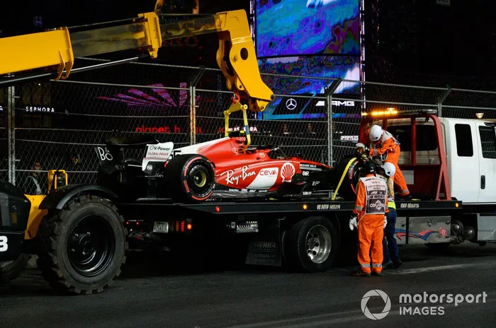 Los comisarios cargan el coche dañado de Carlos Sainz, Ferrari SF-23, en un camión