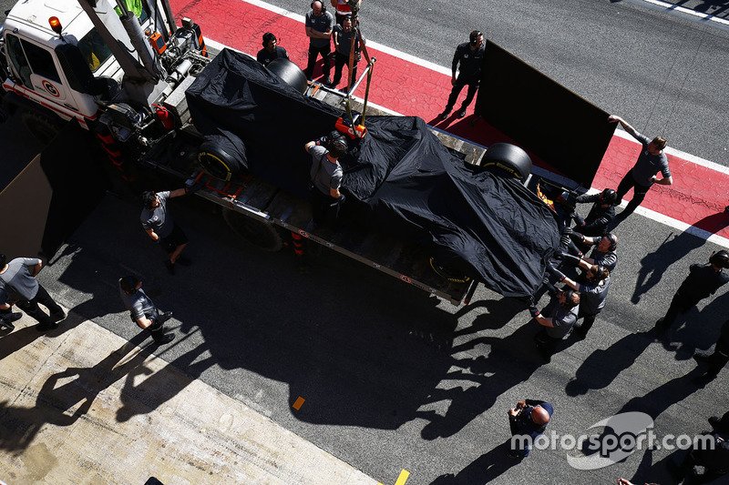 El McLaren MCL32 de Fernando Alonso vuelve al pitlane en un camión