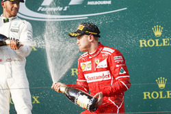 Lewis Hamilton, Mercedes AMG, deuxième et Sebastian Vettel, Ferrari, vainqueur, s'aspergent de champagne sur le podium