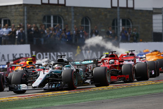 Lewis Hamilton, Mercedes AMG F1 W09, leads Sebastian Vettel, Ferrari SF71H, and the remainder of the field as Fernando Alonso, McLaren MCL33, crashes out in the background