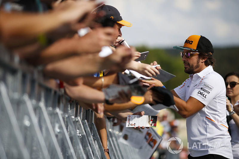 Fernando Alonso, McLaren, signs autographs for fans