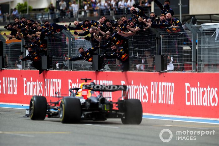 Max Verstappen, Red Bull Racing RB16B, 1ª posición, cruza la línea de meta para la victoria entre los vítores de su equipo en el muro de boxes
