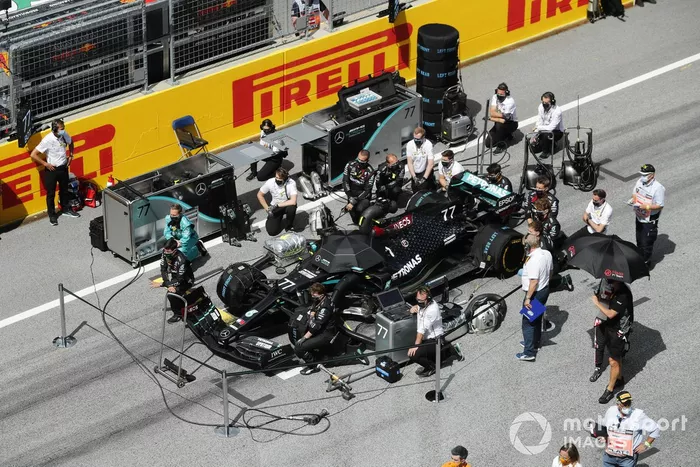 Los ingenieros y mecánicos de Mercedes se ponen de rodillas en la parrilla