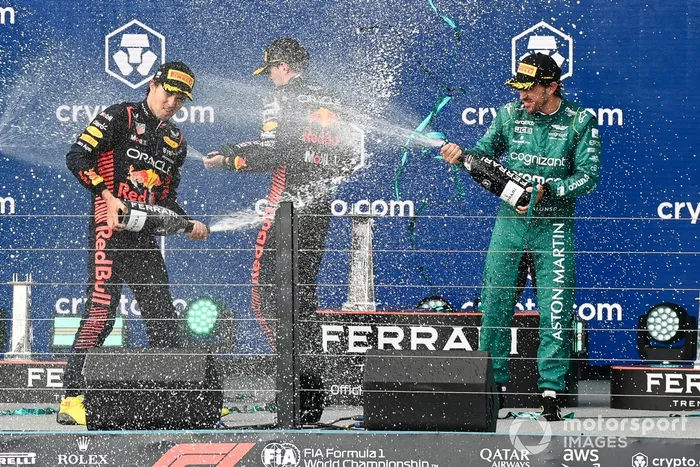 El delegado del trofeo Red Bull, Sergio Pérez, Red Bull Racing, 2ª posición, Max Verstappen, Red Bull Racing, 1ª posición, Fernando Alonso, Aston Martin F1 Team, 3ª posición, rocían Champán en el podio.