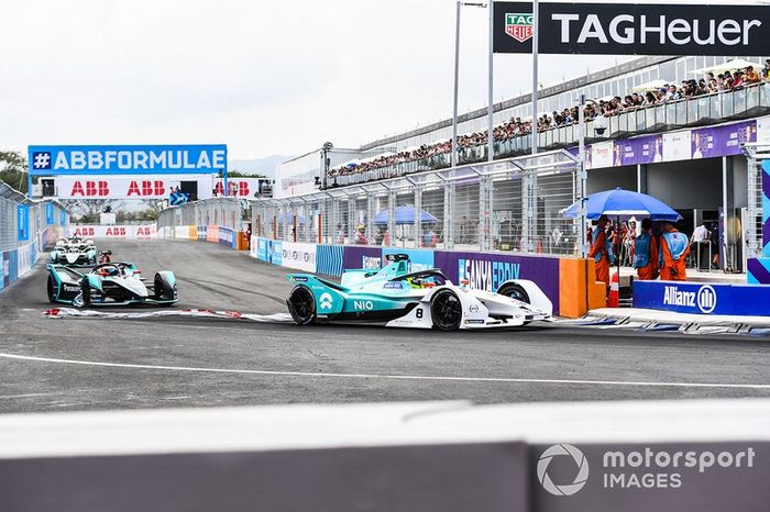 Tom Dillmann, NIO Formula E Team, NIO Sport 004, con una pancarta publicitaria colgada de su coche, Mitch Evans, Panasonic Jaguar Racing, Jaguar I-Type 3 